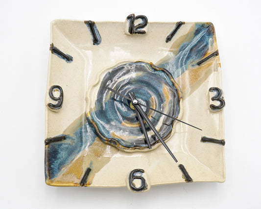 Square ceramic wall clock with blue and beige design on a white background
