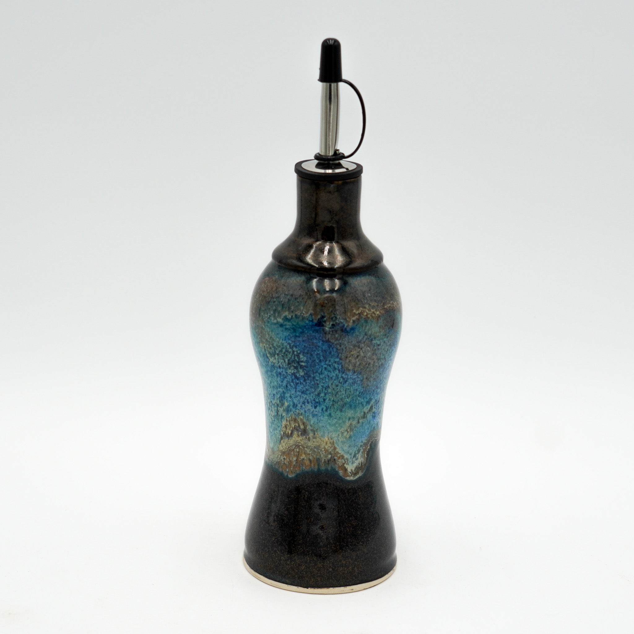 Ceramic oil bottle with blue and black design on a white background