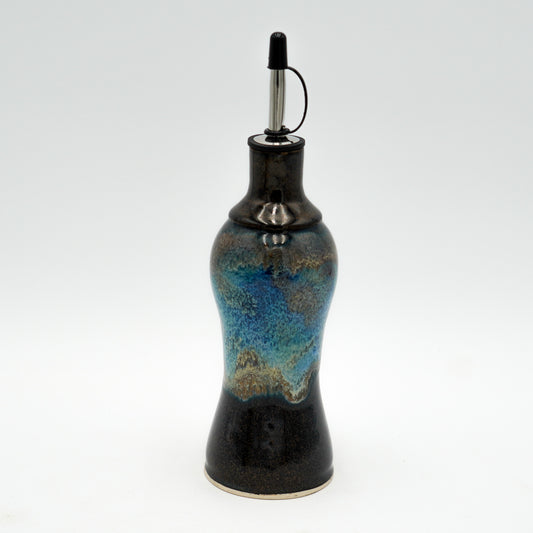 Ceramic oil bottle with blue and black design on a white background