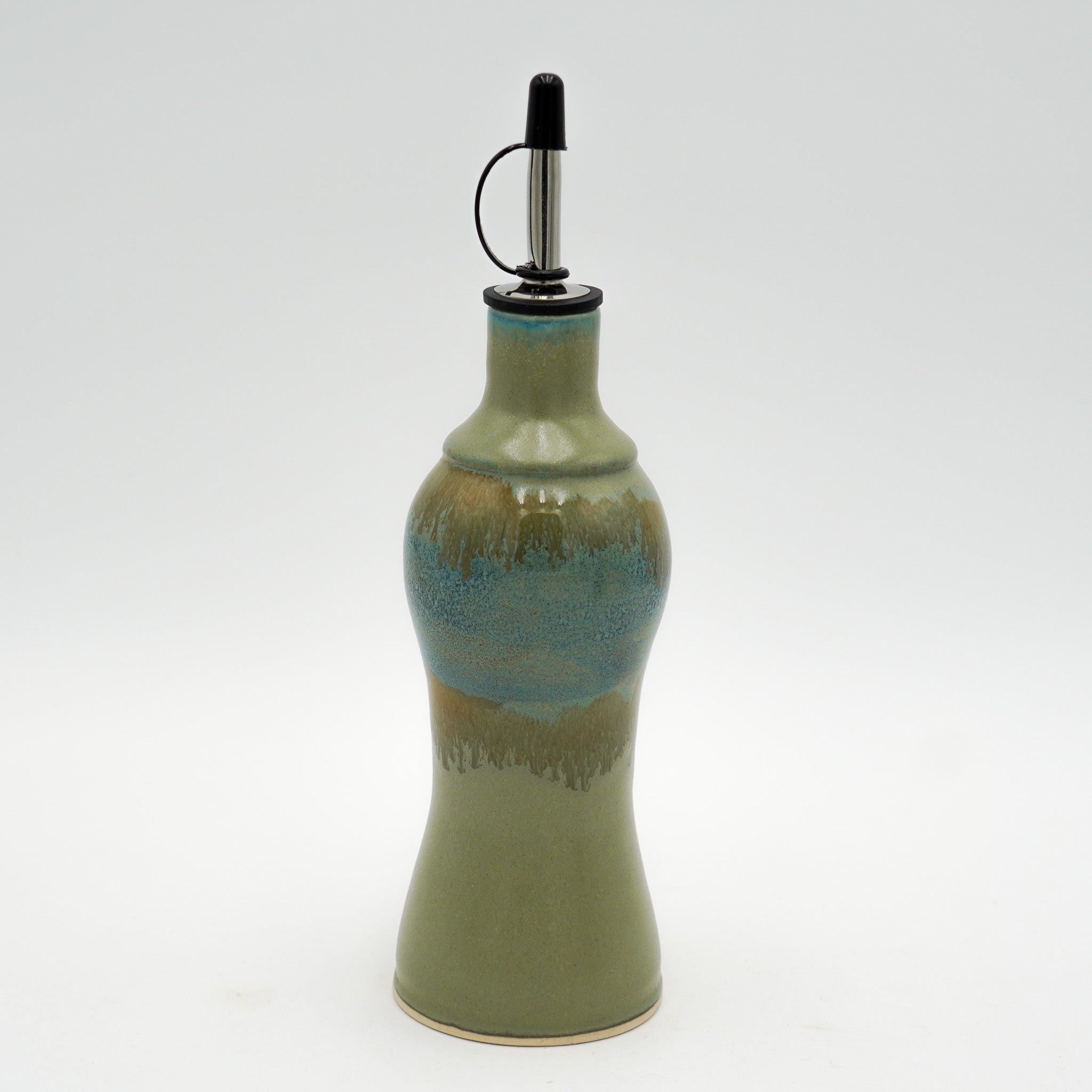Green ceramic oil bottle with a metallic nozzle on a white background