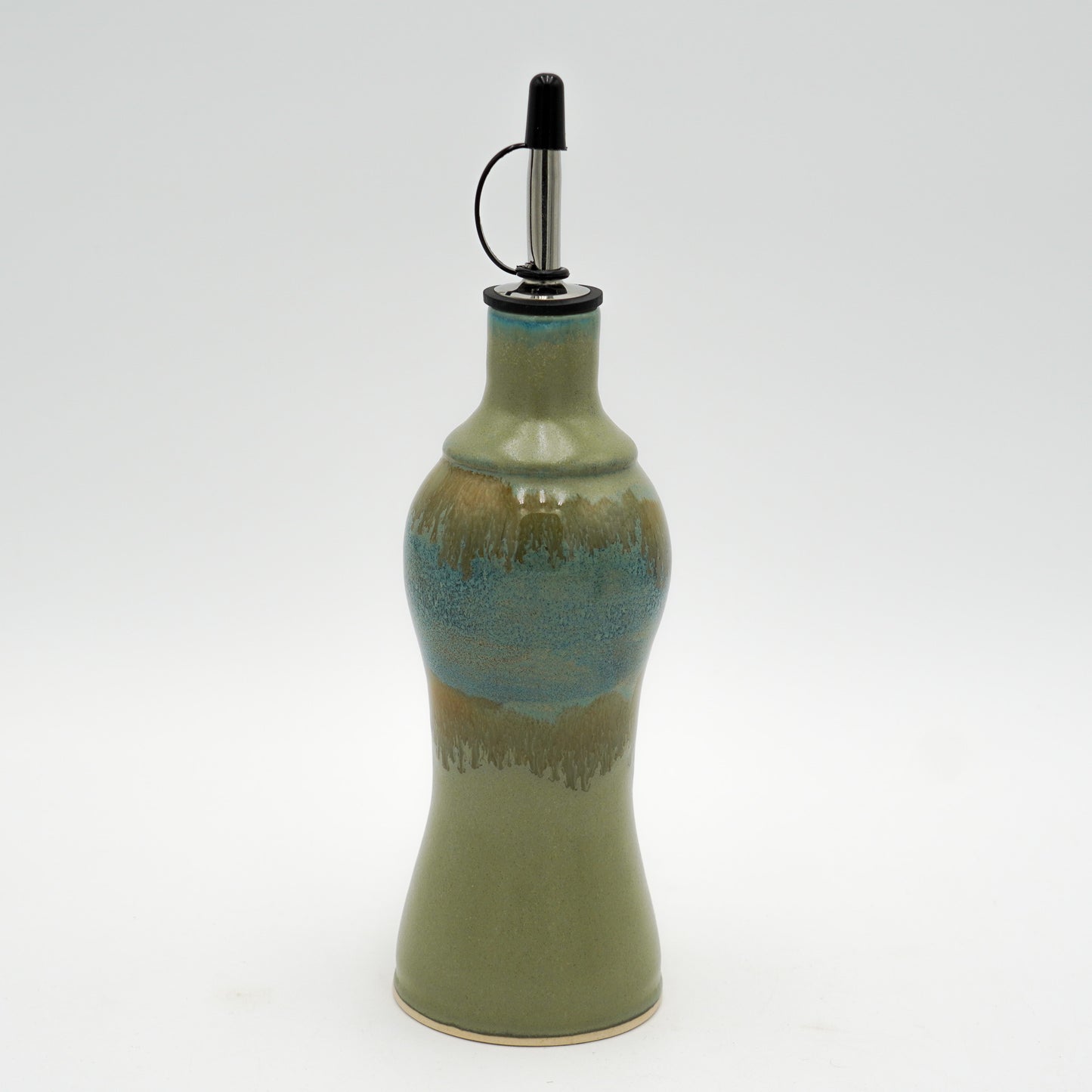 Green ceramic oil bottle with a metallic nozzle on a white background
