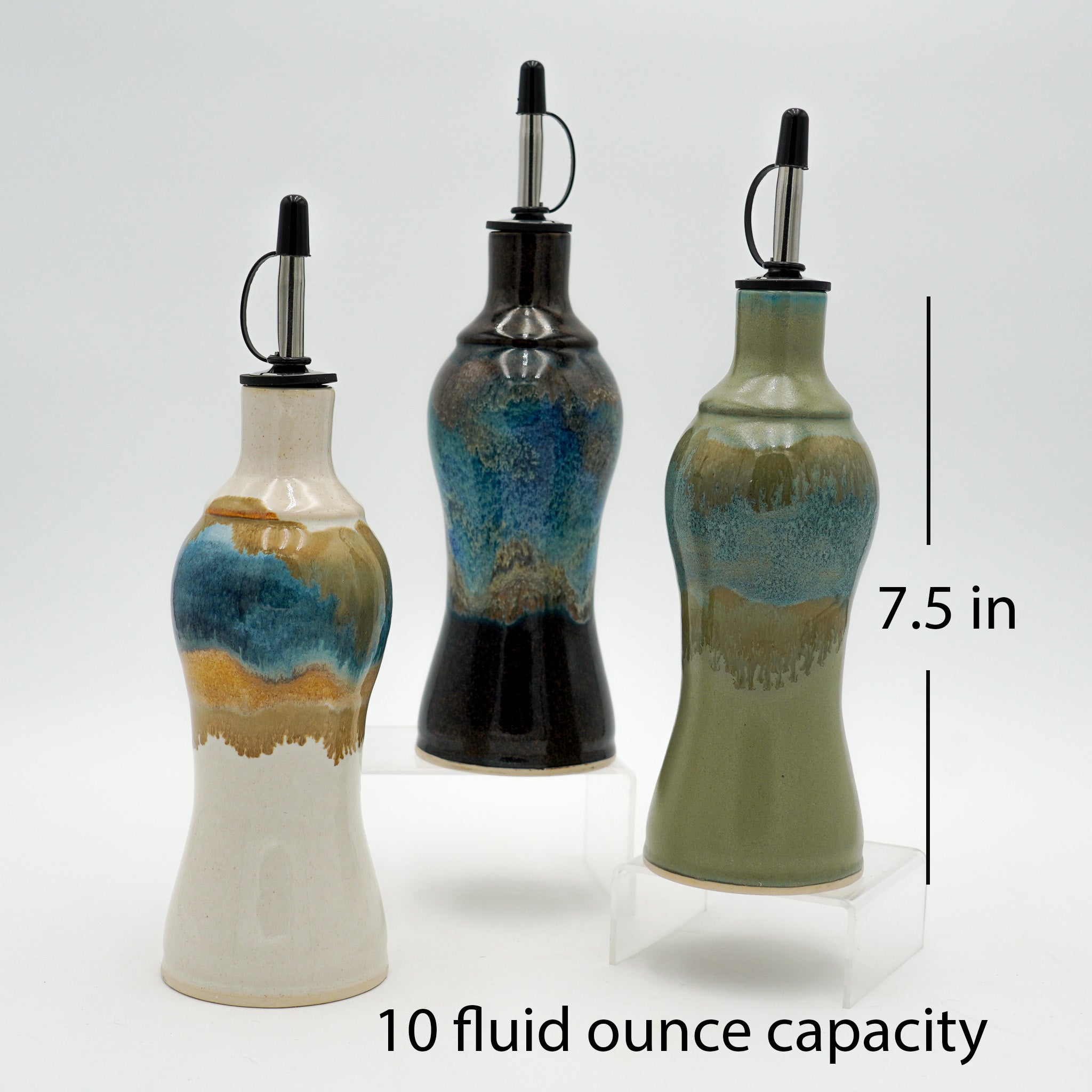 Three ceramic oil bottles with a 7.5 inch height and 10 fluid ounce capacity on a white background.